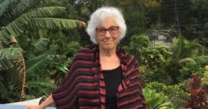 Author Sandra butler outdoors in Hawaii with lush tropical vegetation